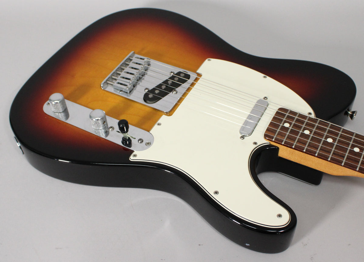 Sunburst Telecaster body, angled from above, showing a white pickguard, chrome bridge, black bridge pickup, and two knurled knobs.