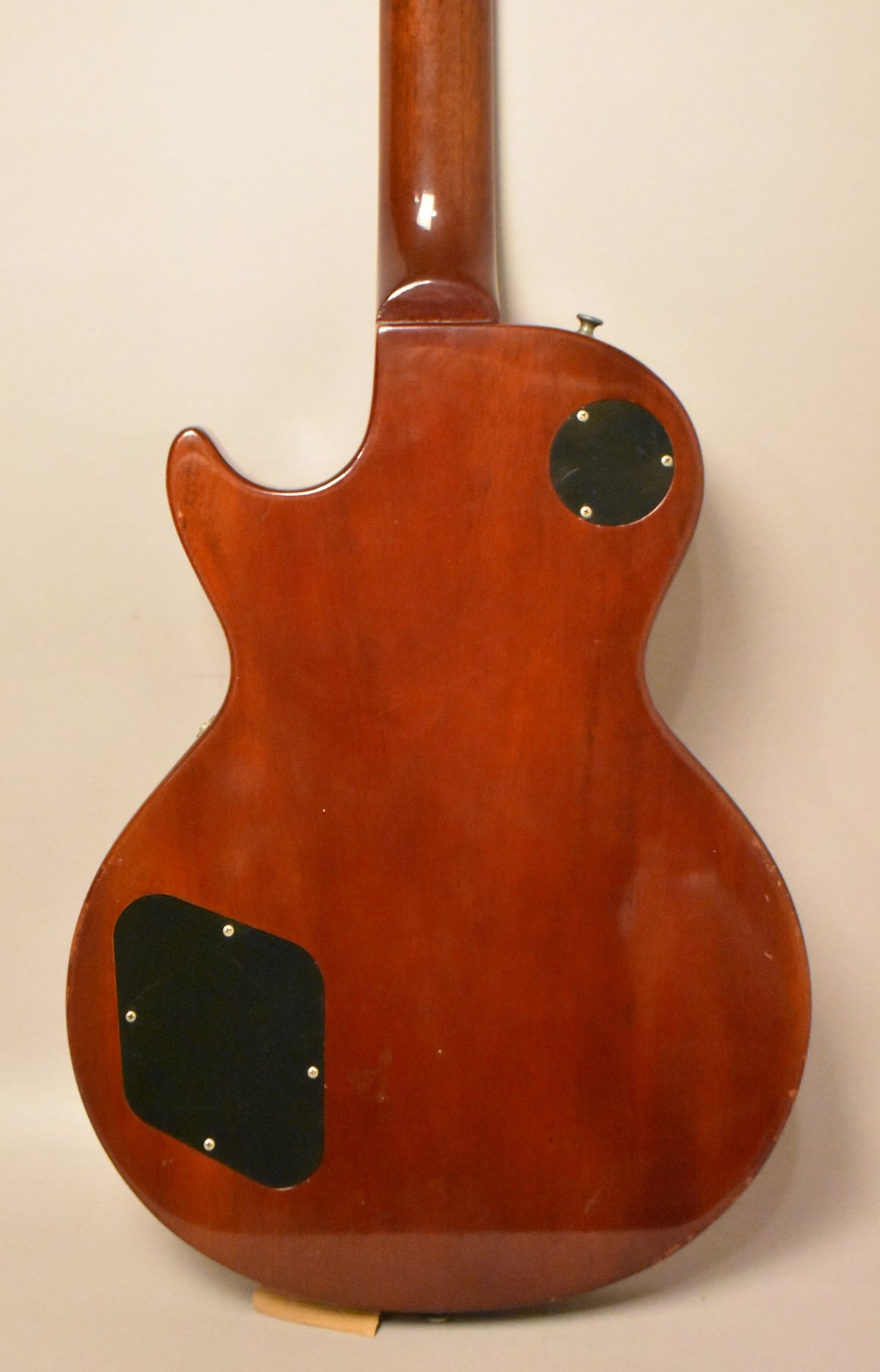 The guitar's cherry sunburst back and neck are visible, with two black control cavity covers and light finish wear.