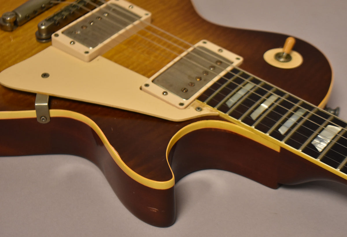 Close-up of the guitar's lower bout, showing the sunburst finish, cream binding, pickguard, and neck pickup with visible wear.