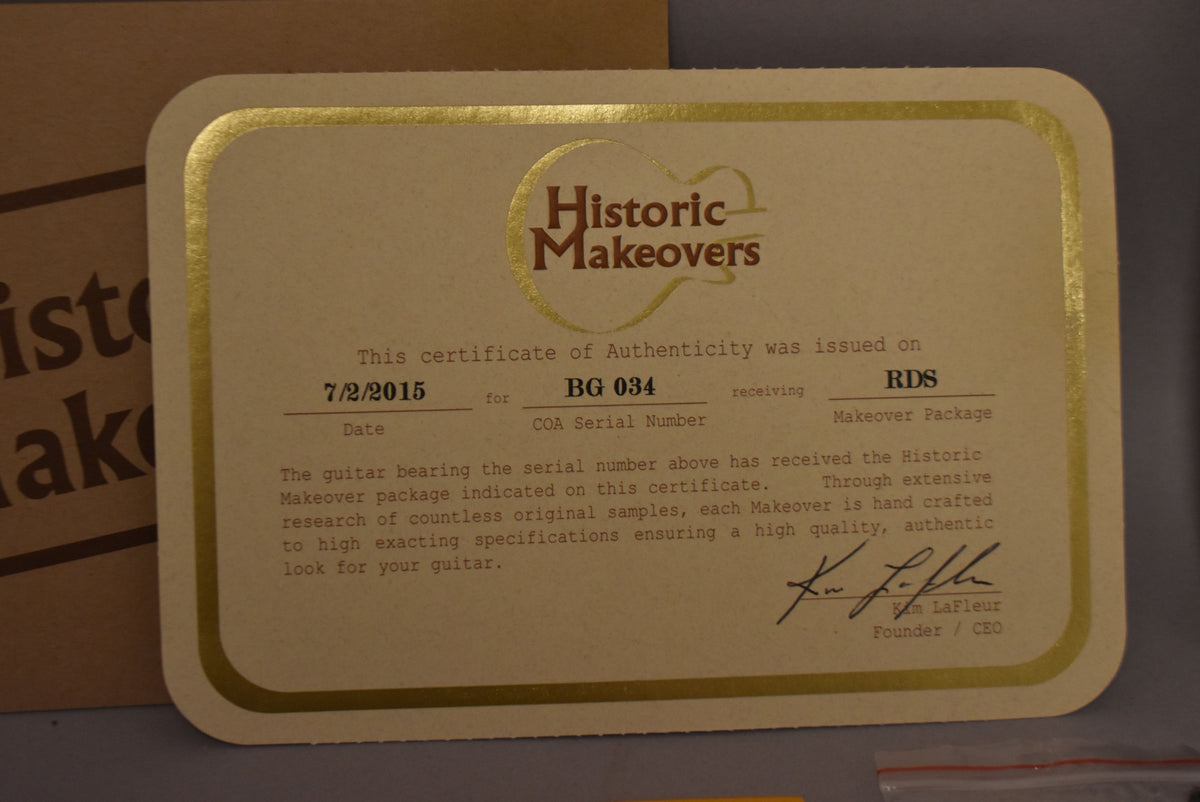 Close-up of a beige Historic Makeovers certificate of authenticity with gold trim, dated 7/2/2015, serial number BG 034.