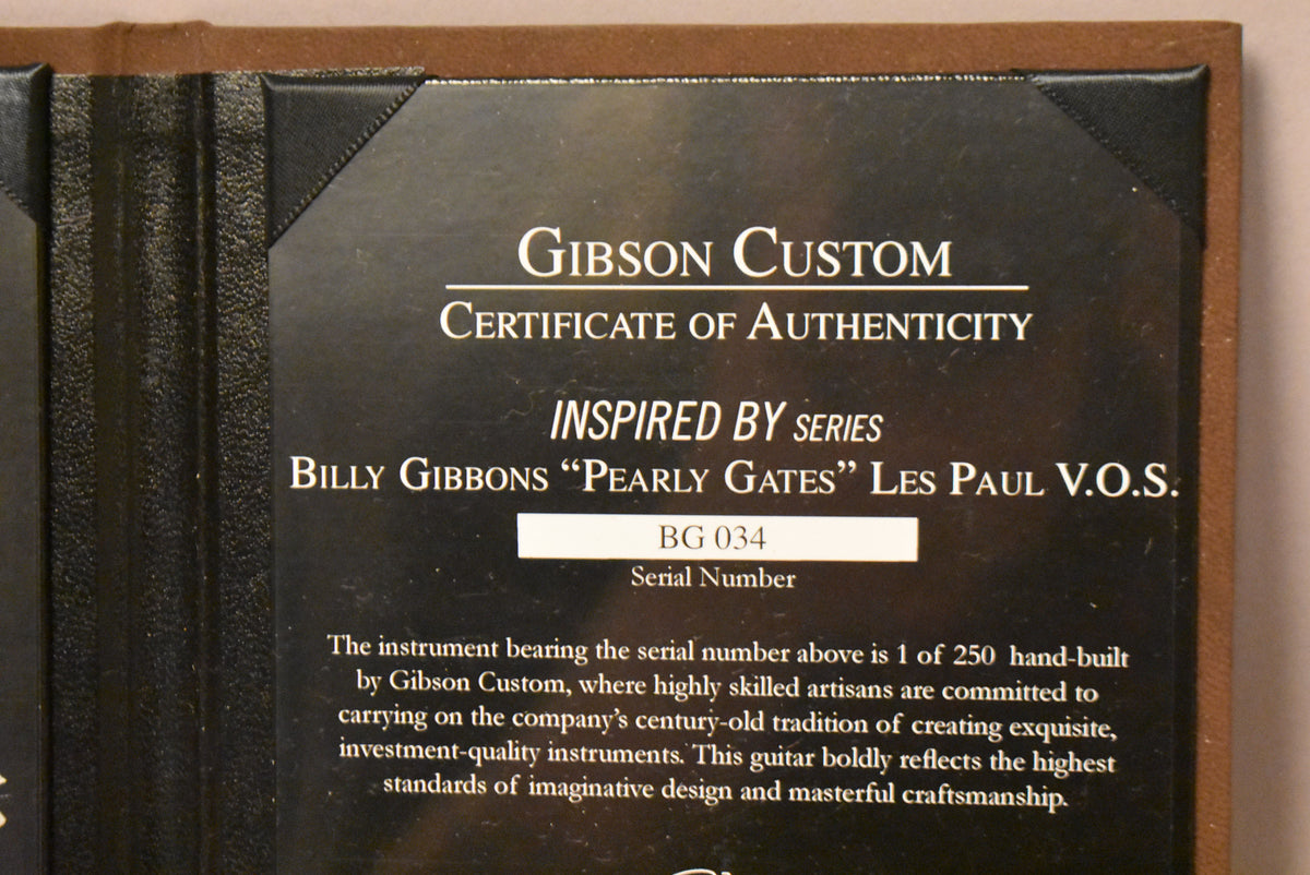 A close-up of the black Certificate of Authenticity, held in a brown folder, showing serial number BG 034.