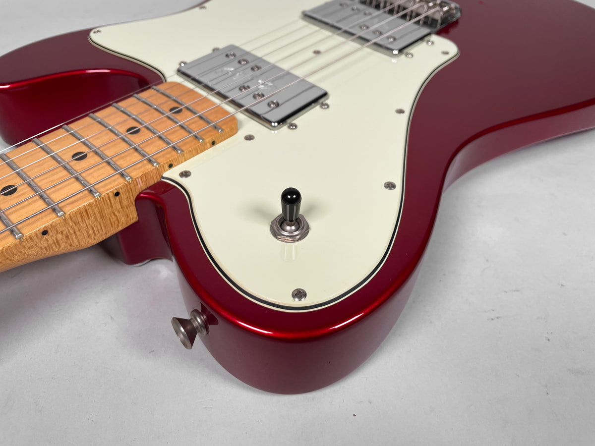 The Candy Apple Red Telecaster's body, with a cream pickguard and black pickup selector, is shown from the lower bout.