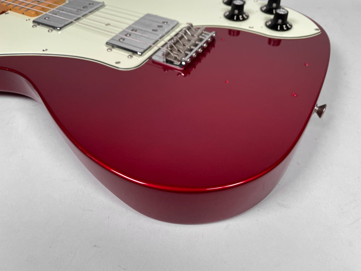Upper body of a Candy Apple Red Telecaster, showing the glossy finish, cream pickguard, two humbuckers, and four black control knobs.