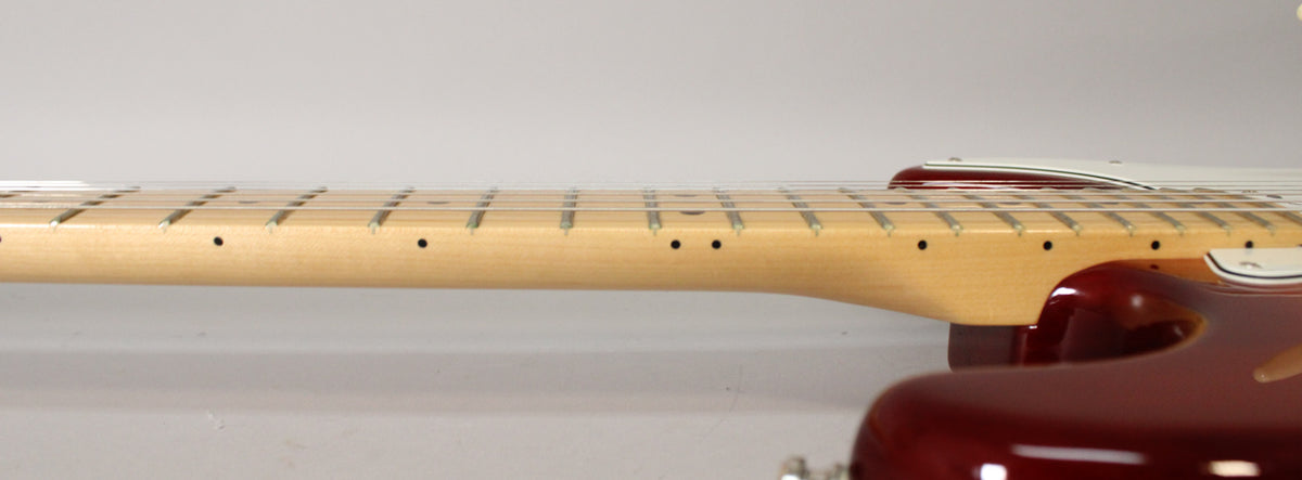 The guitar's maple neck and fretboard are shown from the side, with a Sienna Burst body and white pickguard visible.