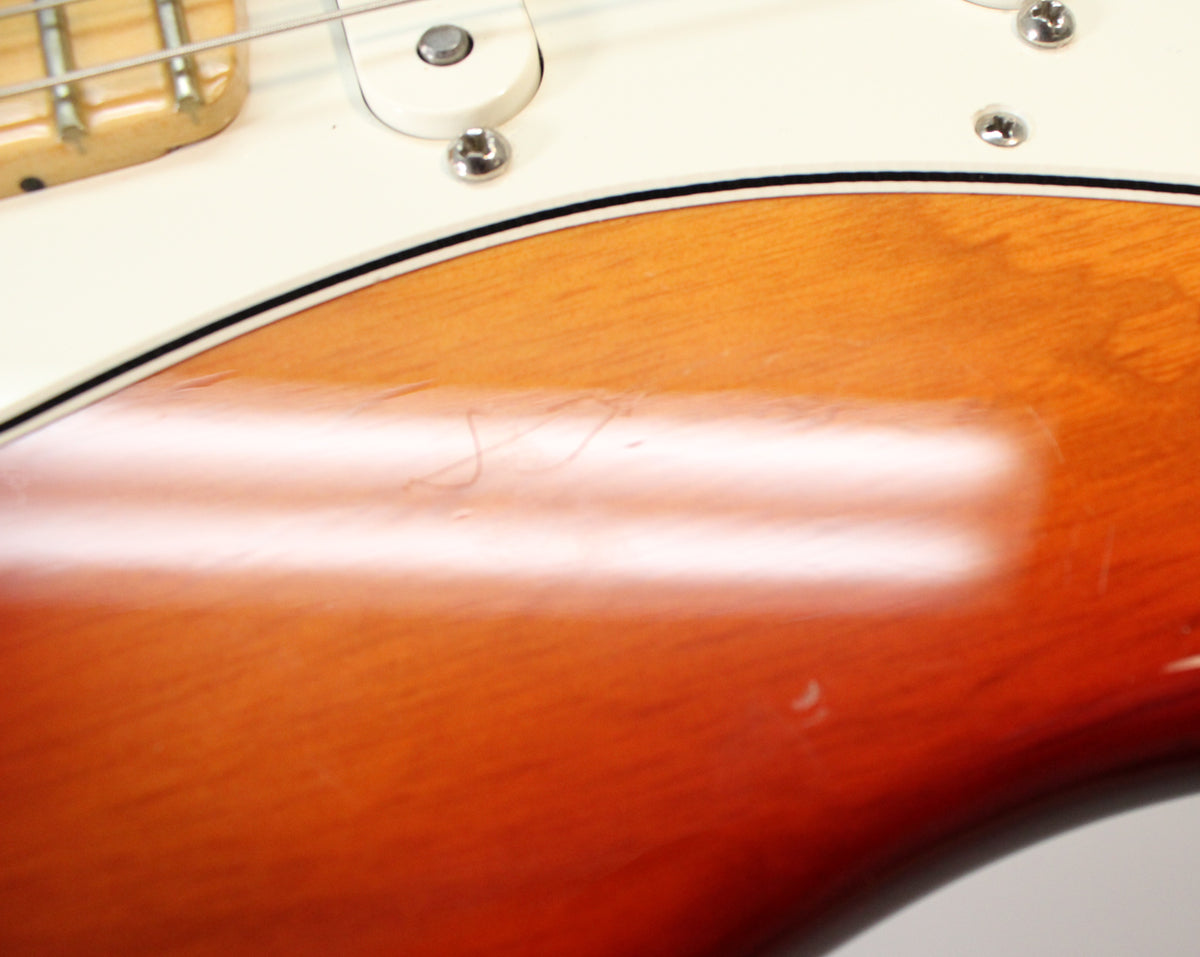 Close-up of the Sienna Burst body with a white pickguard, showing light scratches and dings on the glossy finish.