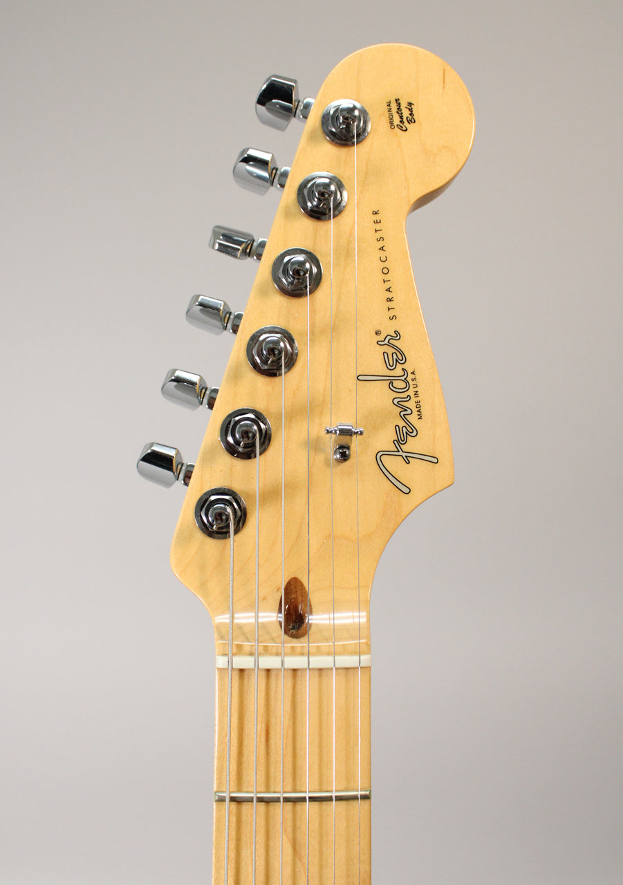 Close-up of the maple headstock and fretboard, showing six chrome tuners, a string tree, and a dark wood string guide.