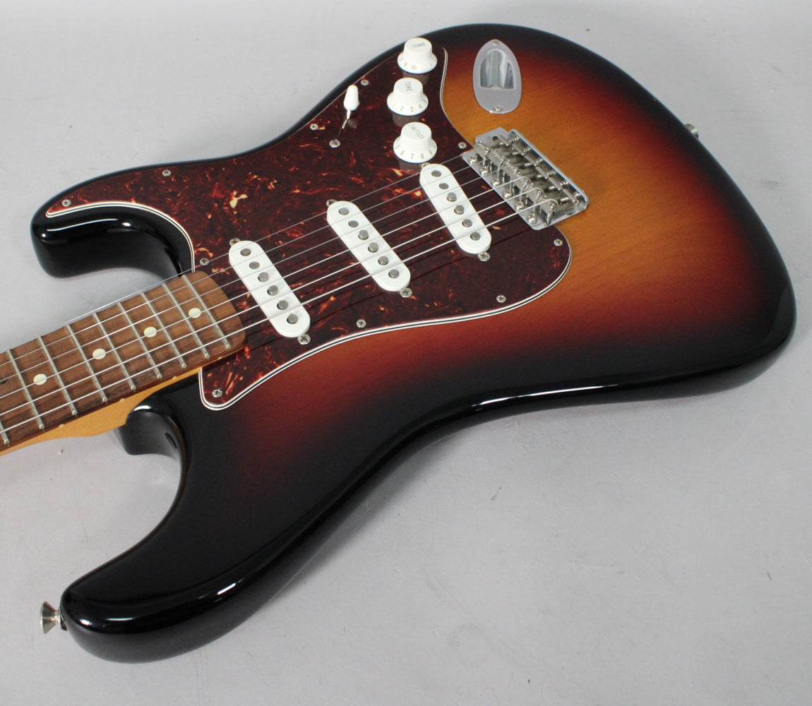 Sunburst Stratocaster body with a tortoiseshell pickguard, three white single-coil pickups, and a chrome tremolo bridge, viewed from above.