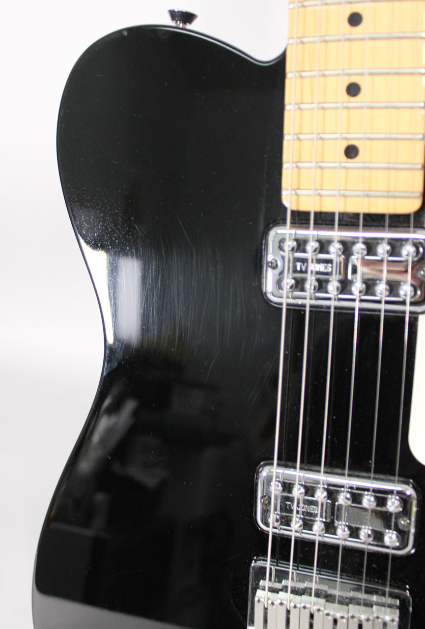 Close-up of the black guitar body with visible pick scratches and dust, showing the lower neck and two chrome TV Jones pickups.