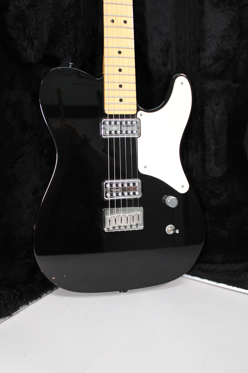 Black electric guitar with a maple fretboard, white pickguard, two chrome humbuckers, a single volume knob, and a three-way switch.