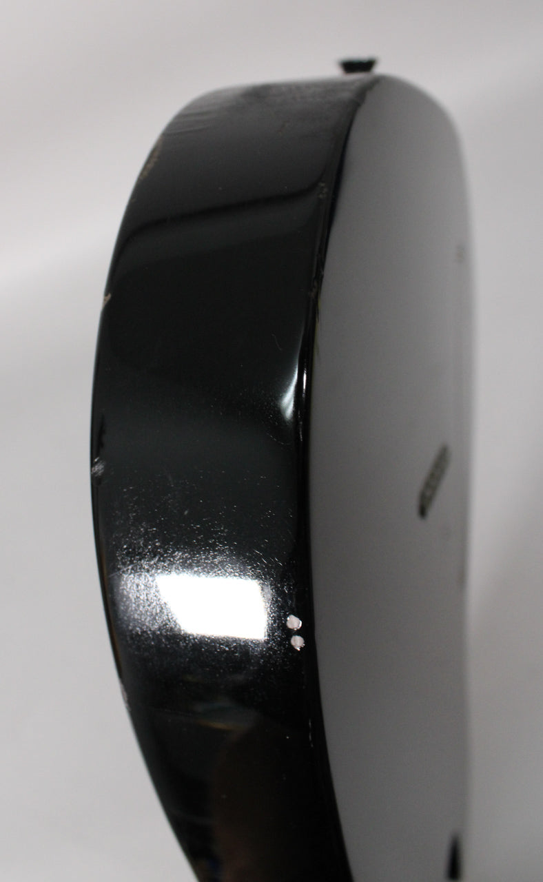 The black guitar body's curved edge shows light scratches, scuffs, and two small white chips near the bottom.