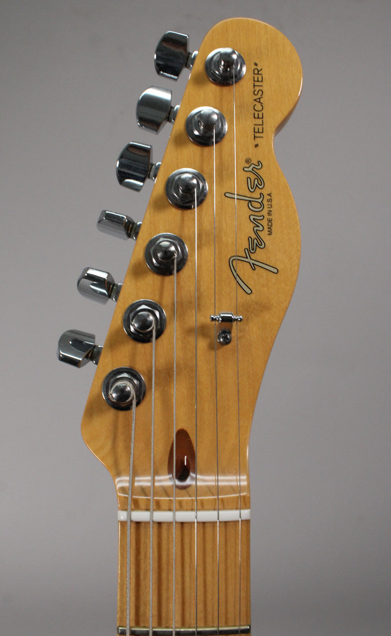 Close-up of the light blonde maple headstock and fretboard, showing six chrome tuners, a string tree, and a white nut.