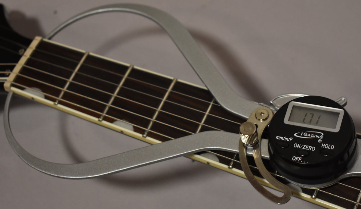 Close-up of the guitar's dark fretboard with white block inlays, measured by a silver digital caliper showing "1.71".
