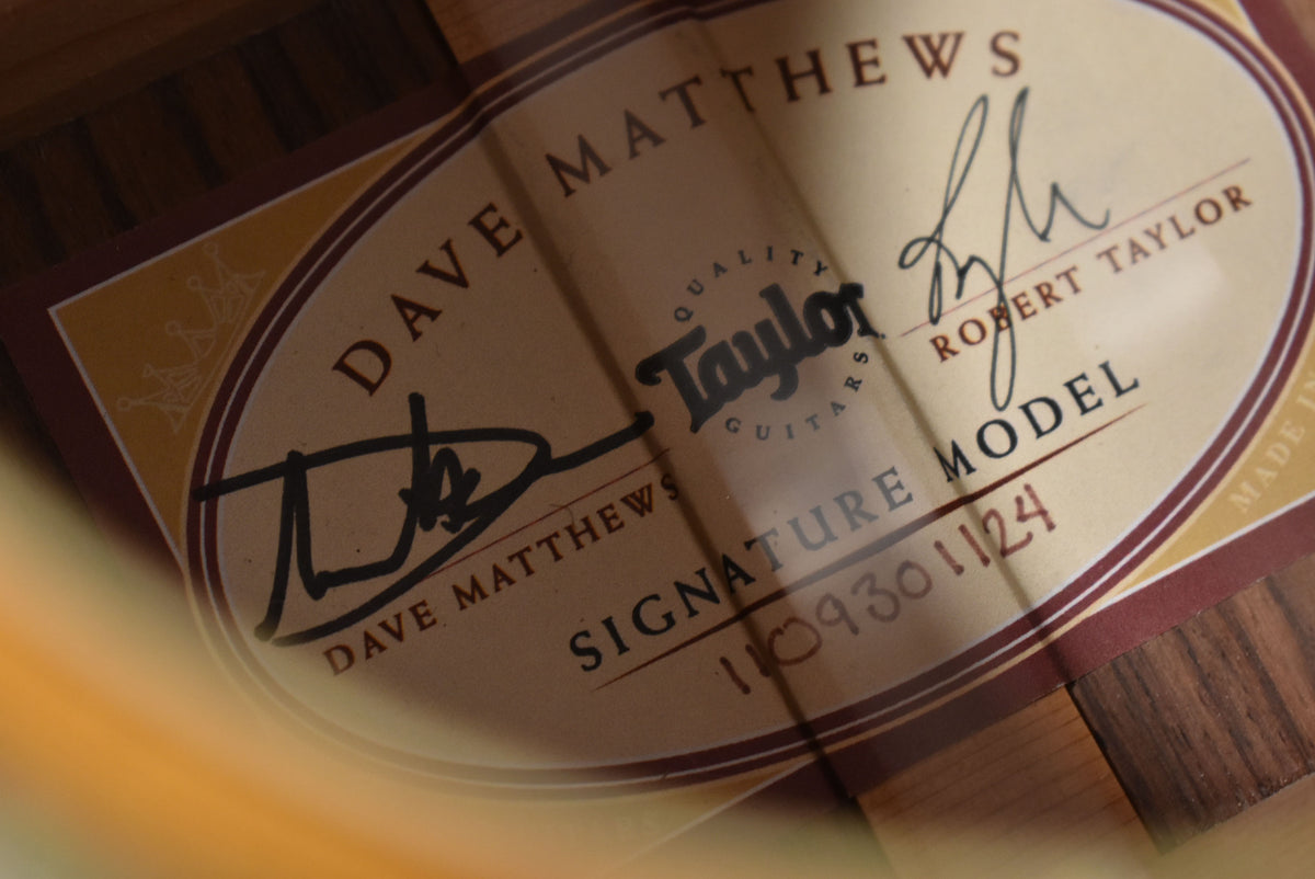 Close-up of the guitar's interior label, showing signatures and "SIGNATURE MODEL" text, with dark wood grain visible around the edges.