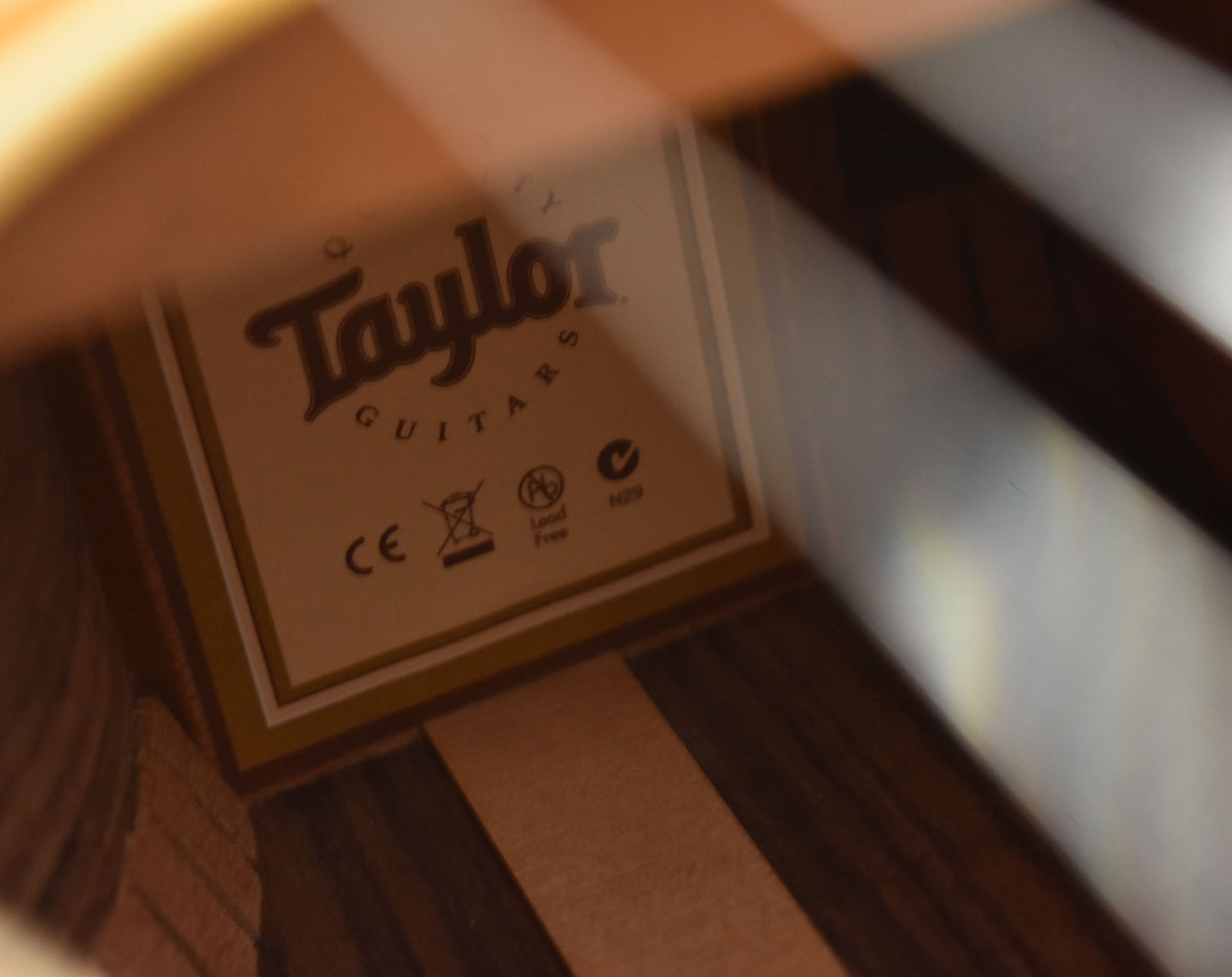 Angled view inside the soundhole, showing the light-colored label with dark text and the dark wood grain.