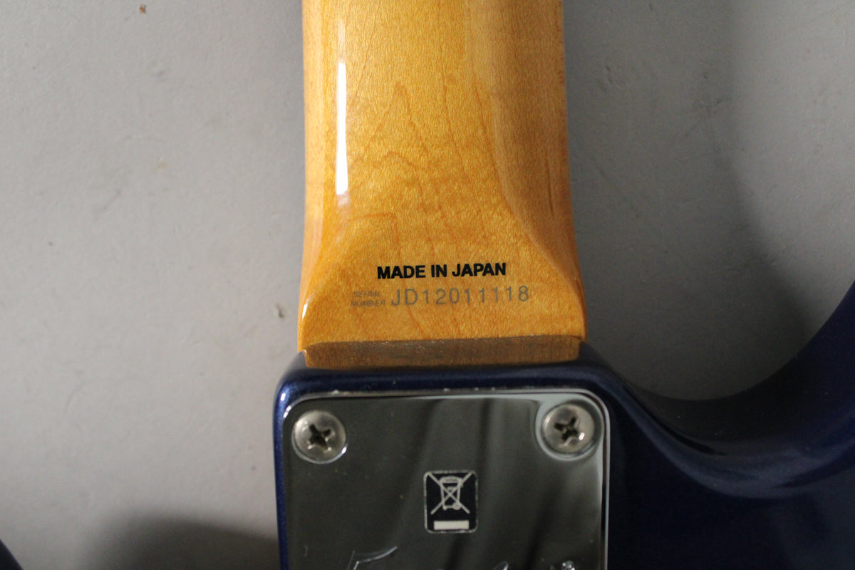 Close-up of the guitar's neck heel and neck plate, showing "MADE IN JAPAN" and serial number JD12011118 on the glossy maple.
