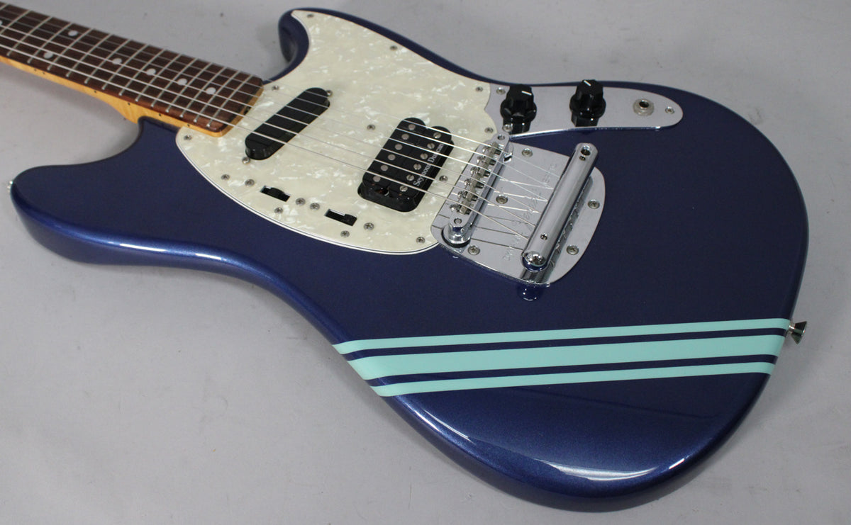 Sparkling blue guitar body with a pearloid pickguard, two pickups, chrome bridge, and two light blue racing stripes.