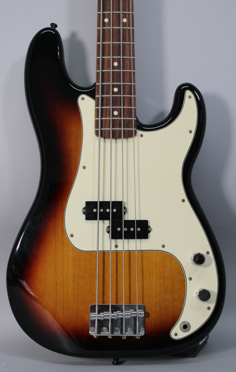 Full-frame view of a sunburst bass with a cream pickguard, split pickup, chrome bridge, and two chrome control knobs.