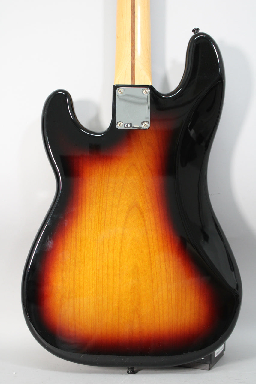 The bass's sunburst back shows a chrome neck plate, a light scratch on the lower bout, and a black strap button.