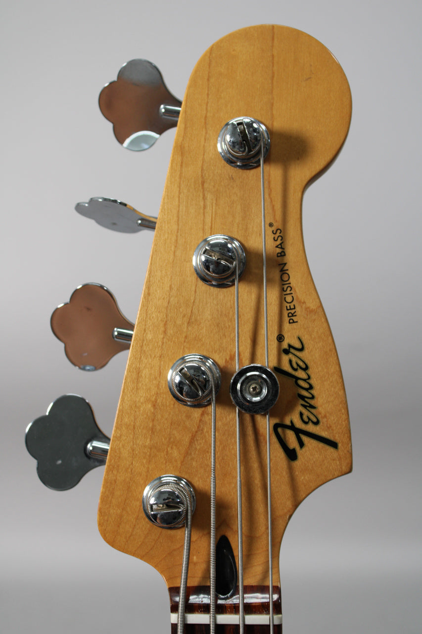 Close-up of the headstock, angled from the left, showing the light maple finish, four chrome tuners, and string tree.