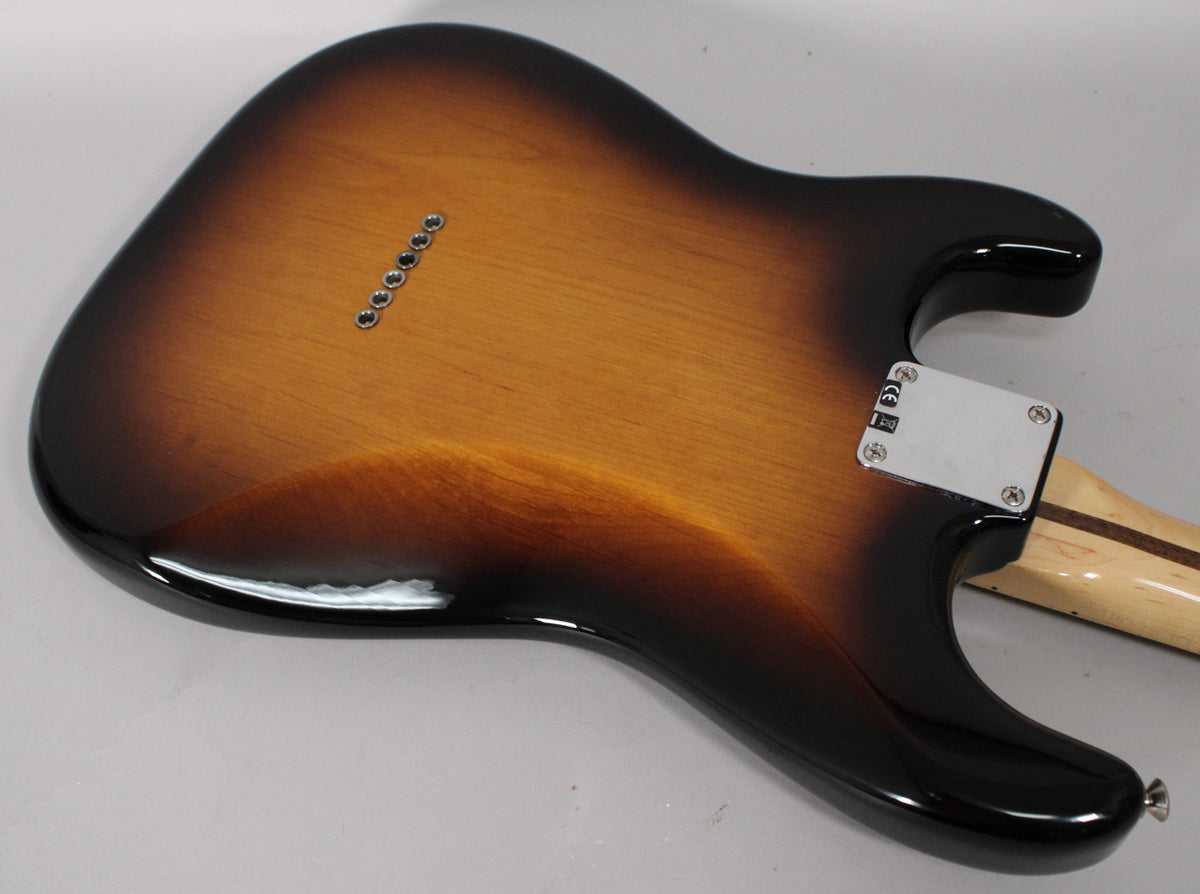 The guitar's back, in 2-color sunburst, shows a chrome neck plate, six string-through-body ferrules, and a small chip on the lower bout.