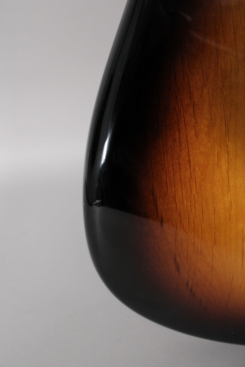 Close-up of the guitar's lower bout, showing a small chip in the glossy 2-color sunburst finish near the dark edge.