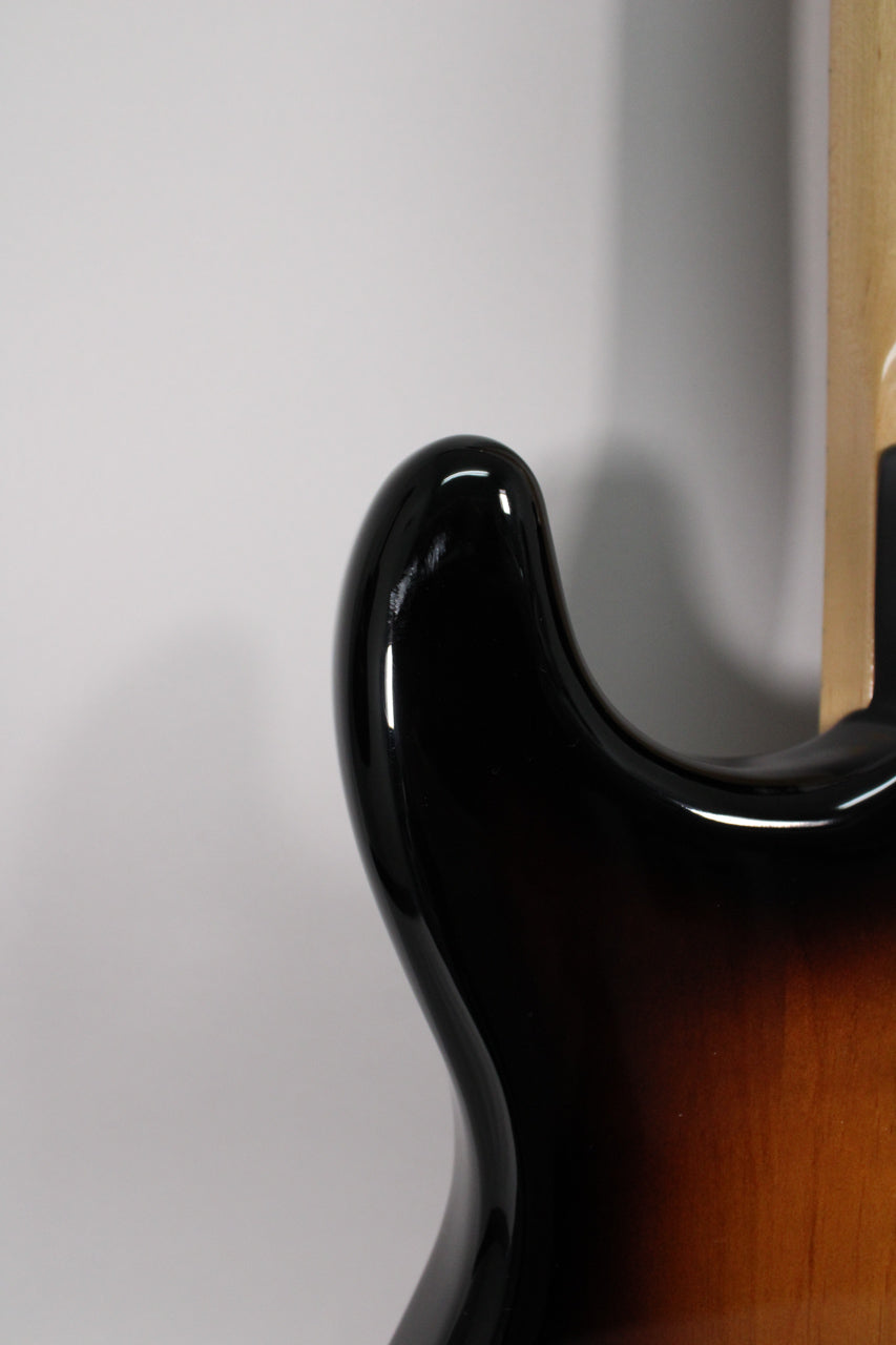 Close-up of the upper horn and cutaway, showing the glossy black-to-brown sunburst finish and a small scratch on the horn.