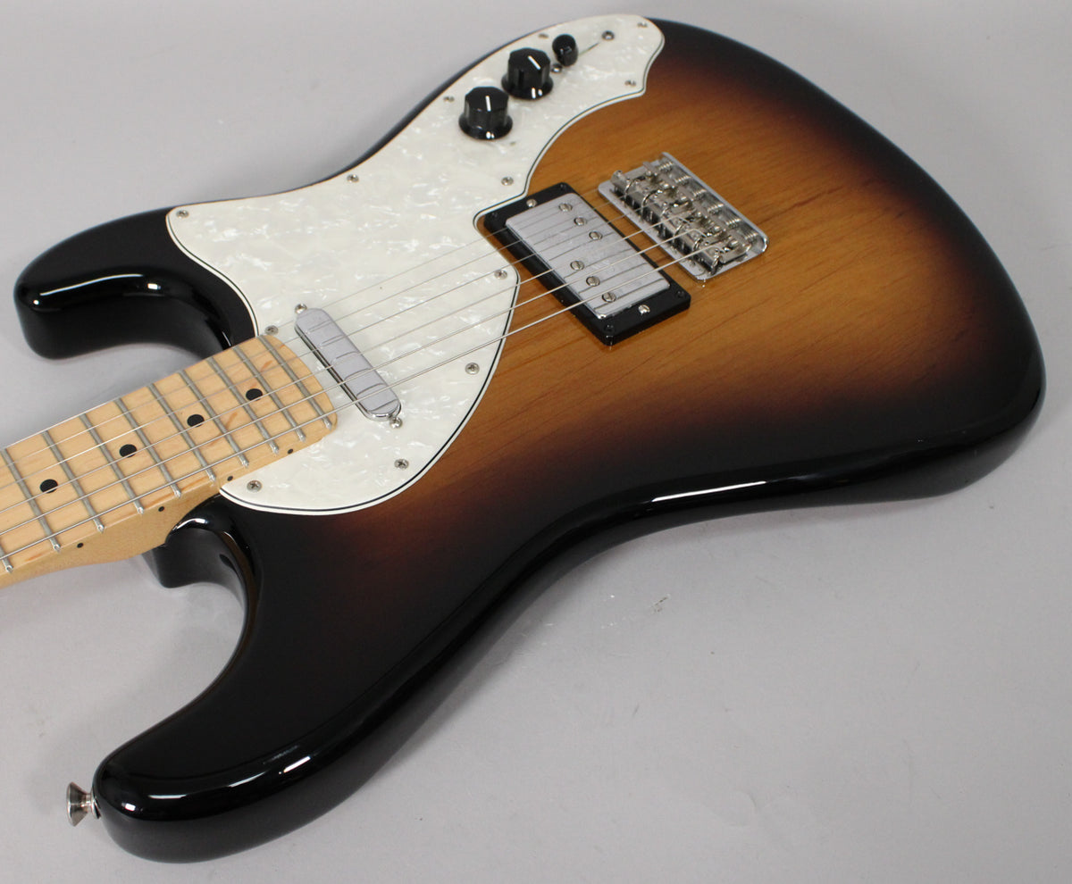 Angled view of a 2-color sunburst guitar with a pearloid pickguard, a single-coil neck pickup, and a humbucker bridge pickup.