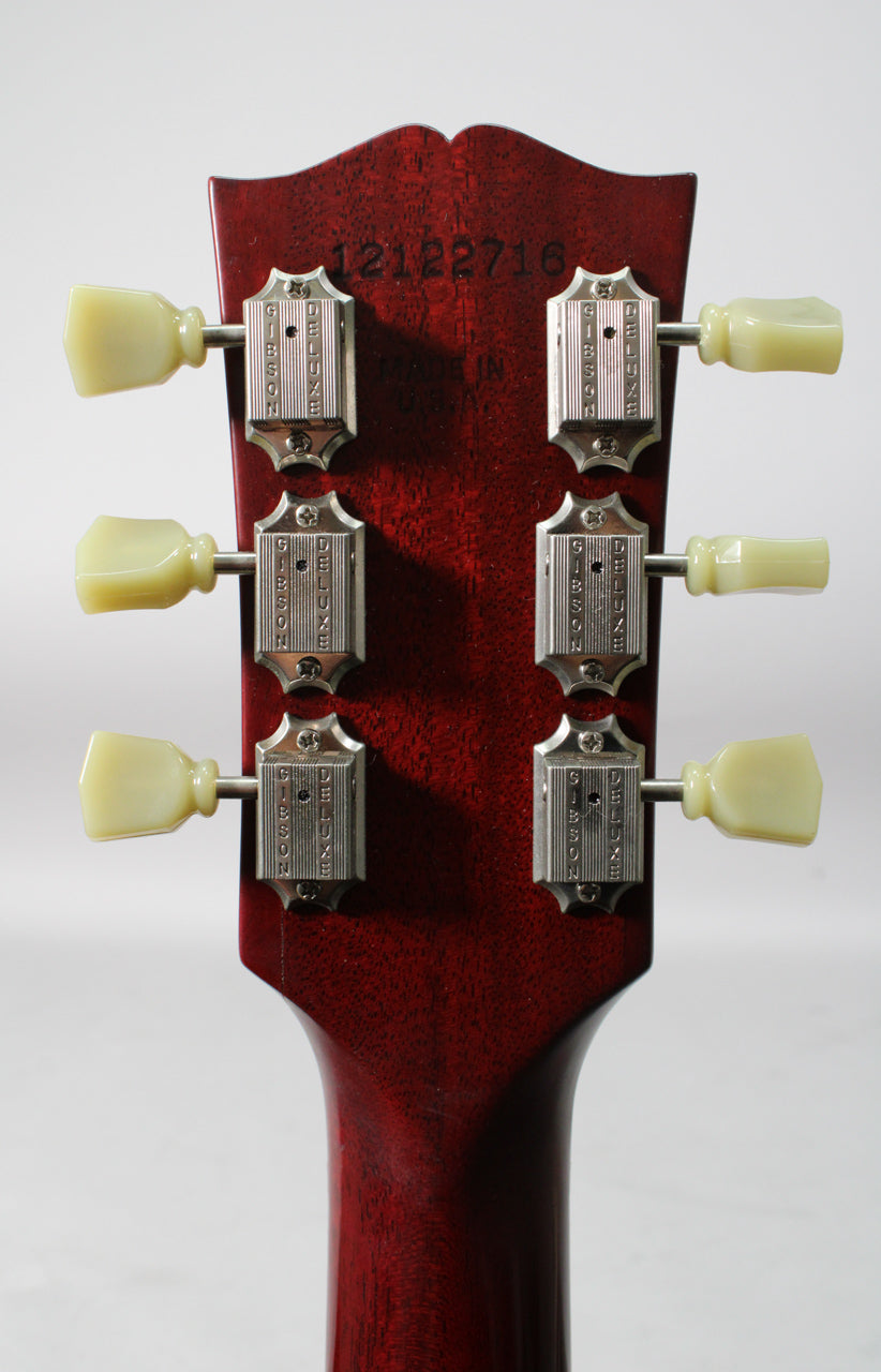 The back of a cherry satin headstock and neck, showing six chrome tuners with cream plastic buttons.