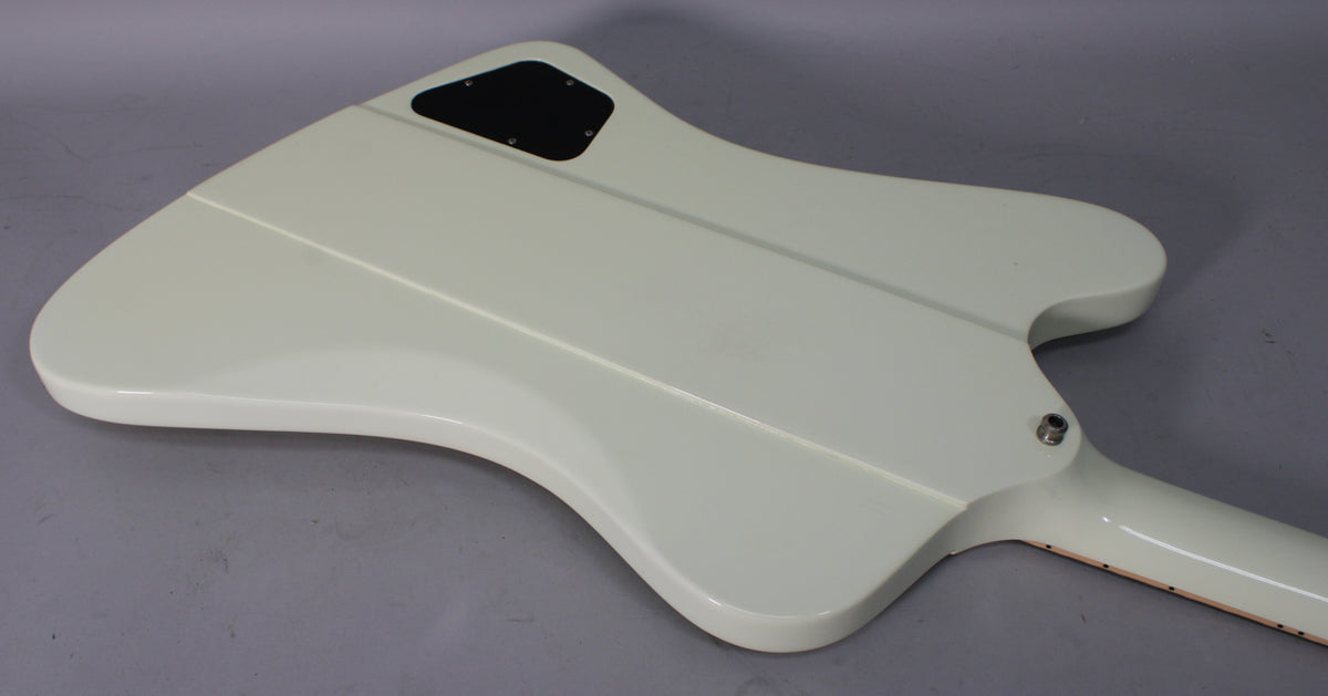 The back of a classic white Firebird body, showing the control cavity cover and the neck joint with output jack.