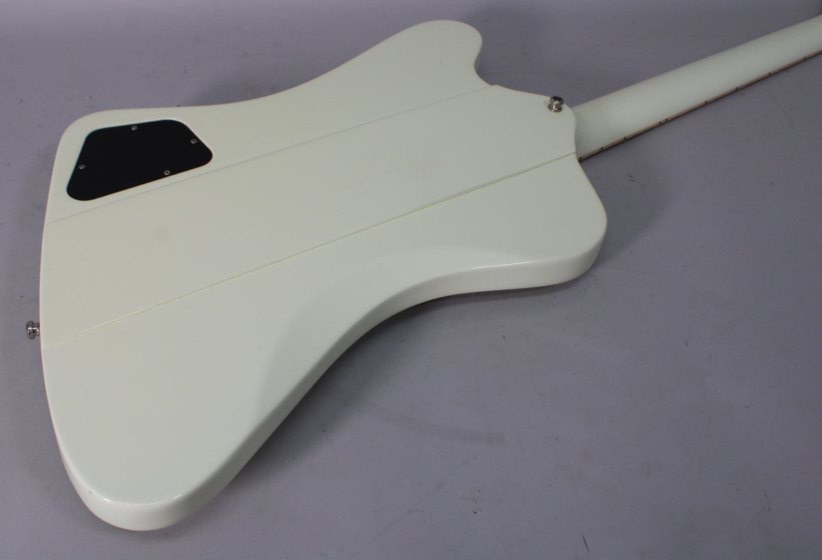 The back of the white guitar body is visible, showing a black control cavity cover and the neck joint with a strap button.