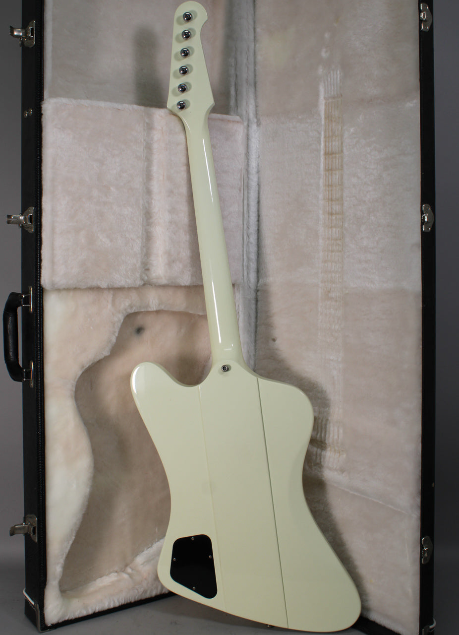 The back of a classic white Firebird guitar with a glossy finish, showing the neck-through construction and black control cavity cover.