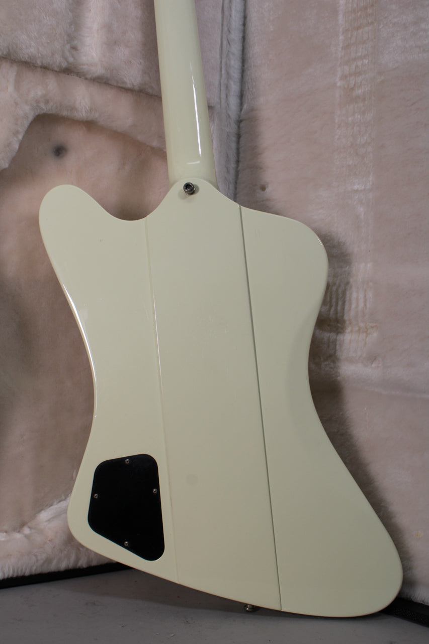 The back of a classic white Firebird guitar, showing the neck joint, black control cavity cover, and light surface wear.