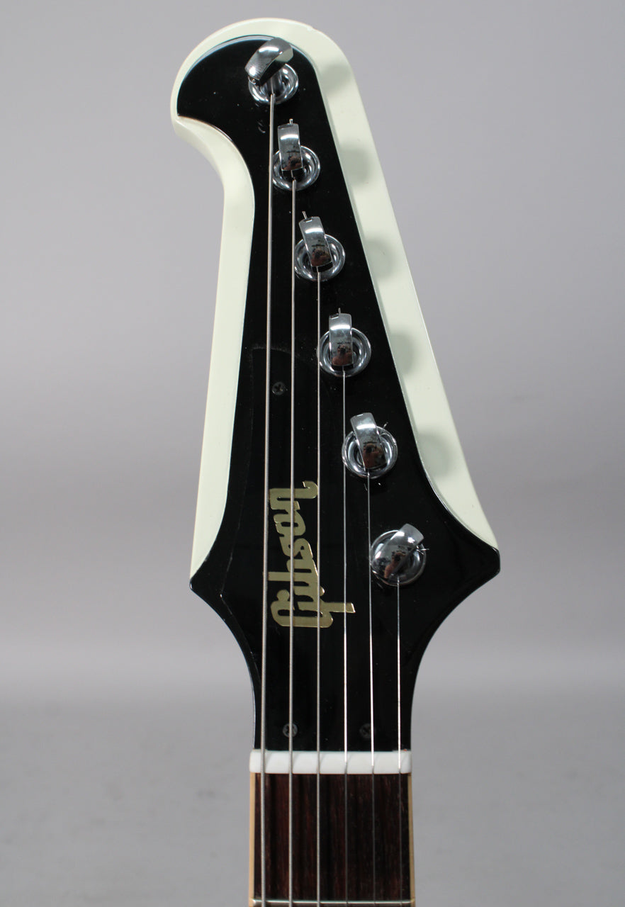 The white-bound black headstock with chrome tuners and gold logo is angled slightly, showing the top of the nut and fretboard.