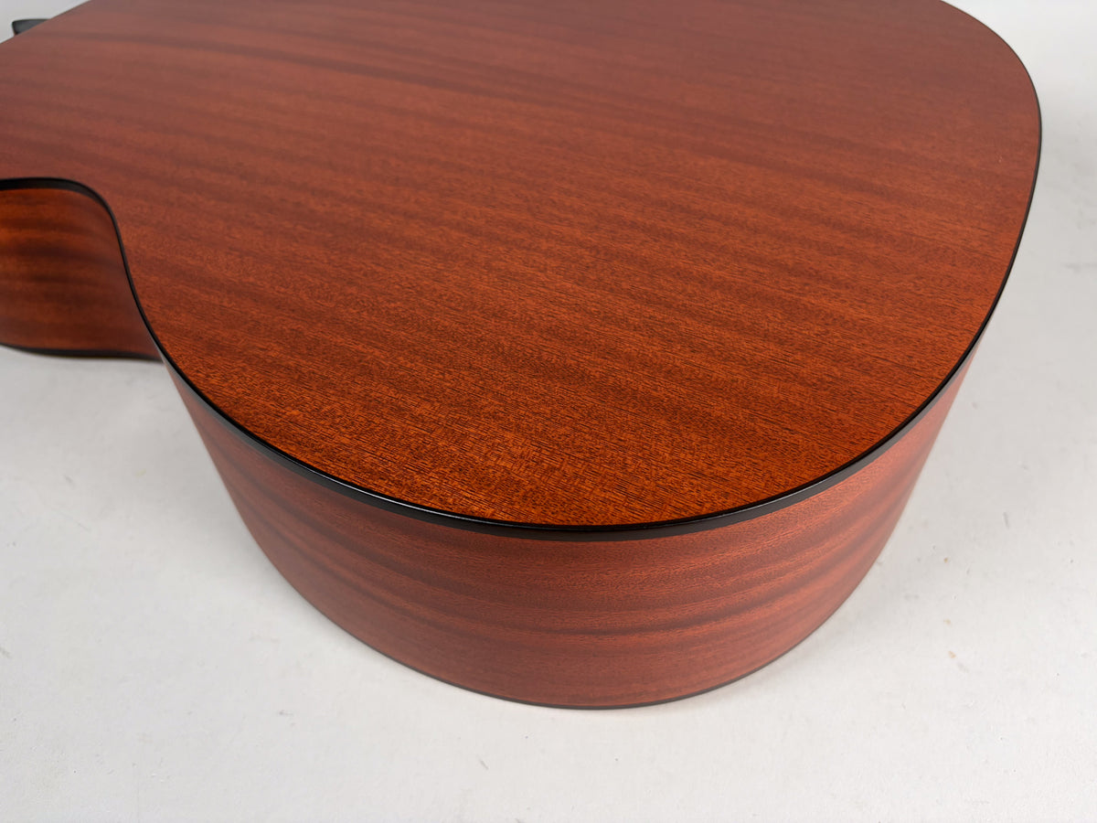 Close-up of the lower bout and cutaway of the guitar, showing the reddish-brown wood grain of the top and sides with a satin finish.