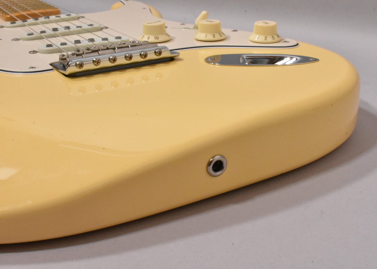 Close-up of the vintage white guitar body, showing the chrome tremolo bridge, three cream control knobs, and output jack.