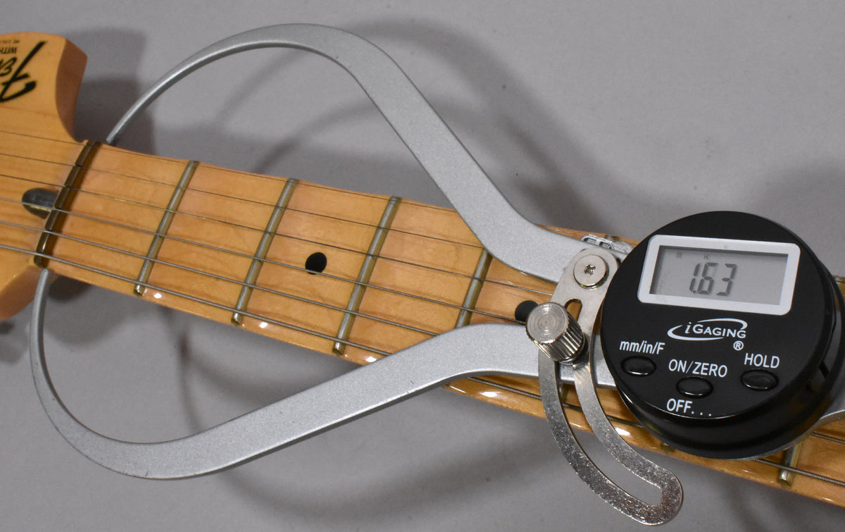 A digital caliper measures the fret height at 1.63mm on the maple fretboard, showing light wear on the frets and fingerboard.