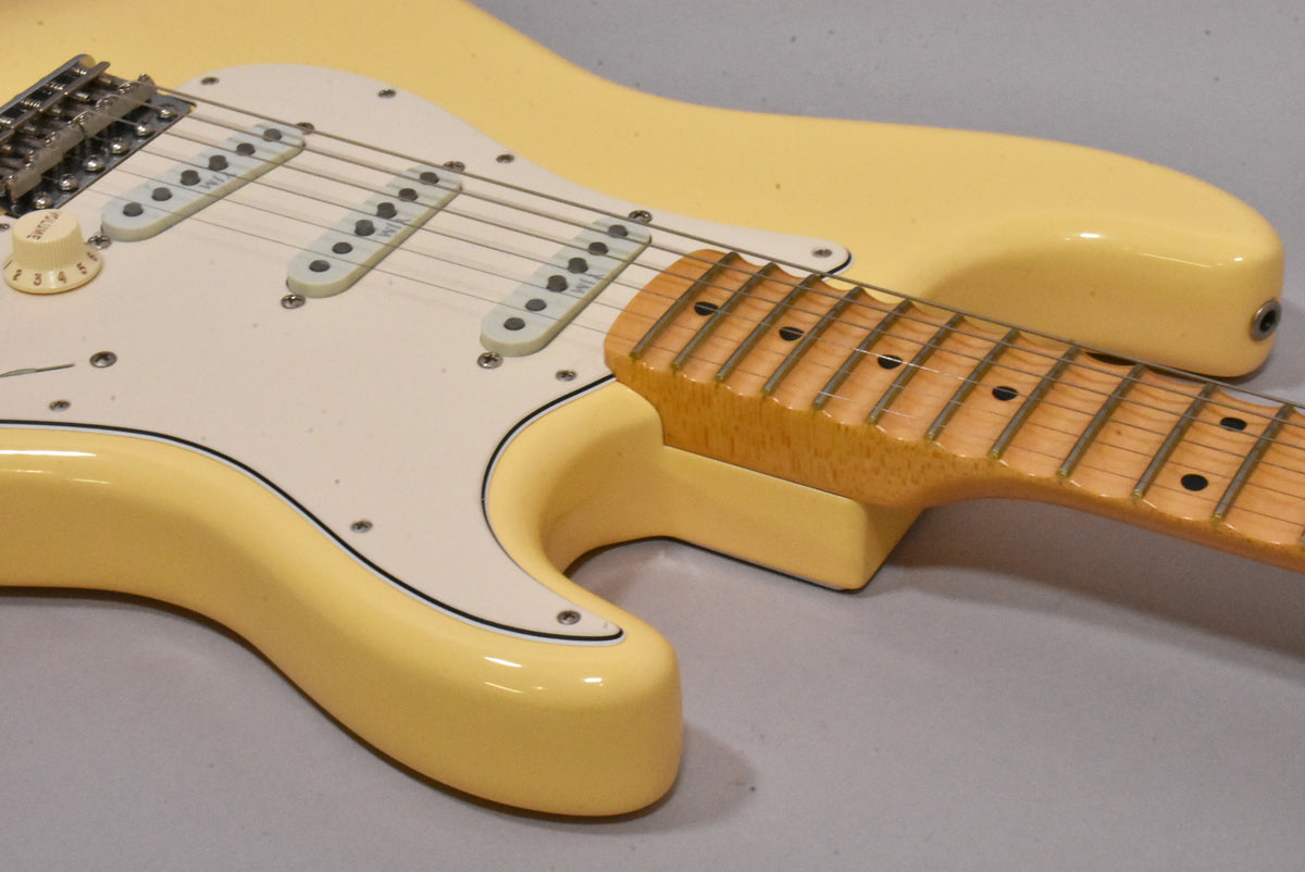 Upper body of a vintage white electric guitar with a white pickguard, three single-coil pickups, and a maple neck with dark fret markers.