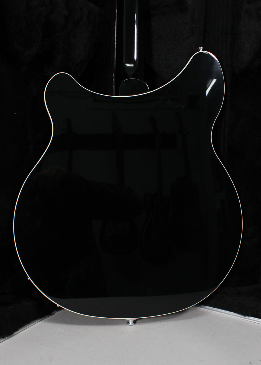 Rear view of the glossy black guitar body, showing its rounded double cutaways and white binding, with a chrome strap button.