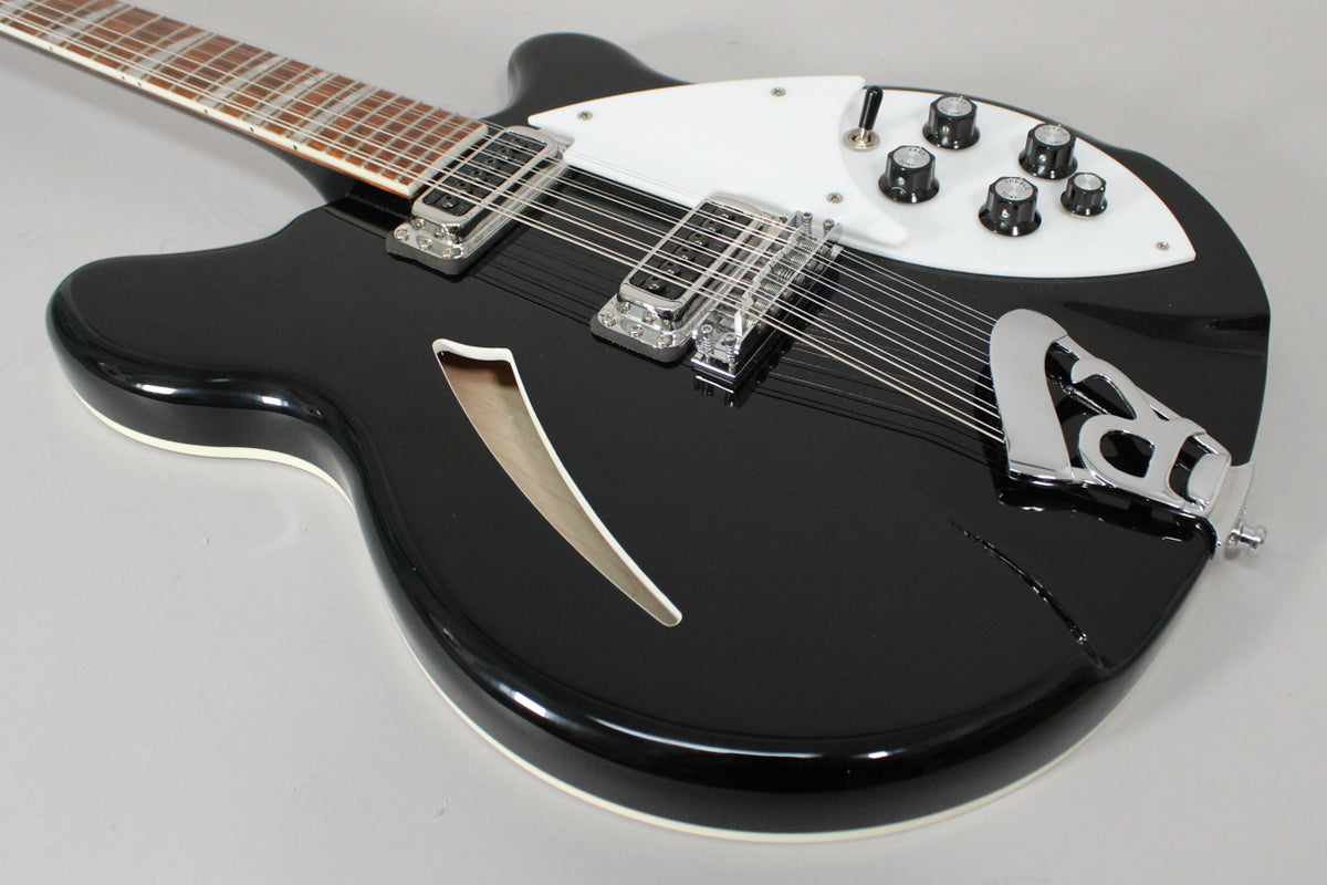 Jetglo 12-string electric guitar, angled from the upper left, showing the body, f-hole, white pickguard, chrome hardware, and six black control knobs.