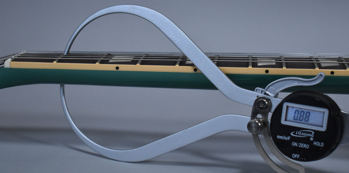 A digital caliper measures the string height above the frets on the Inverness Green neck, showing 0.88mm.