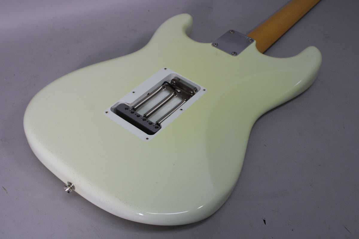 The back of an Olympic White guitar, showing the tremolo spring cavity, neck plate, and some finish wear on the lower bout.