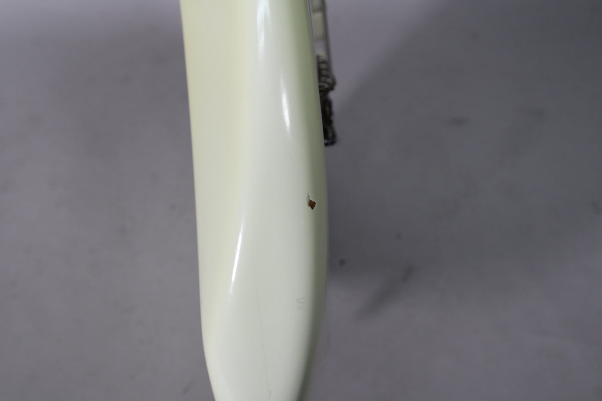 Close-up of the guitar's Olympic White body, showing a small chip in the finish revealing the wood beneath.