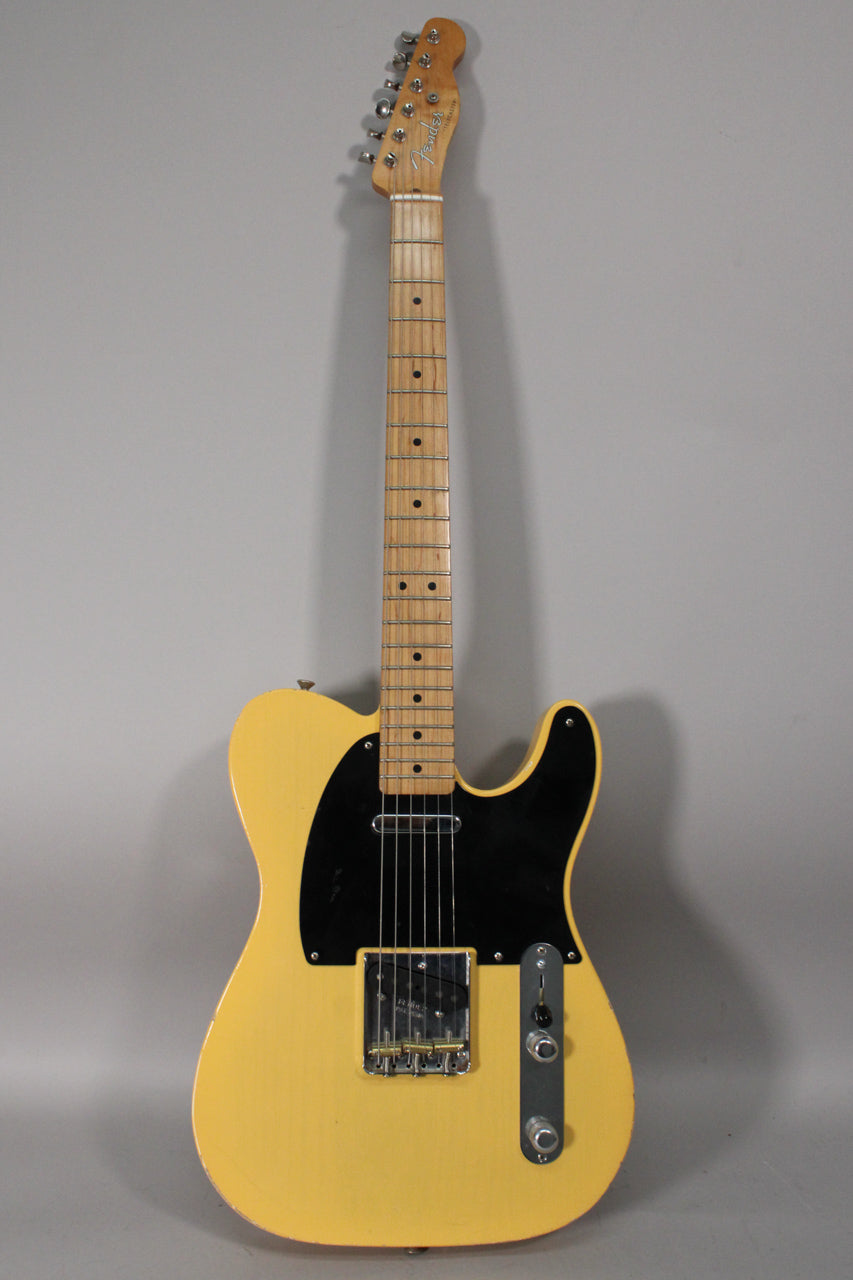 Full-length view of a blonde Telecaster with a black pickguard, maple neck, chrome hardware, and visible finish wear.