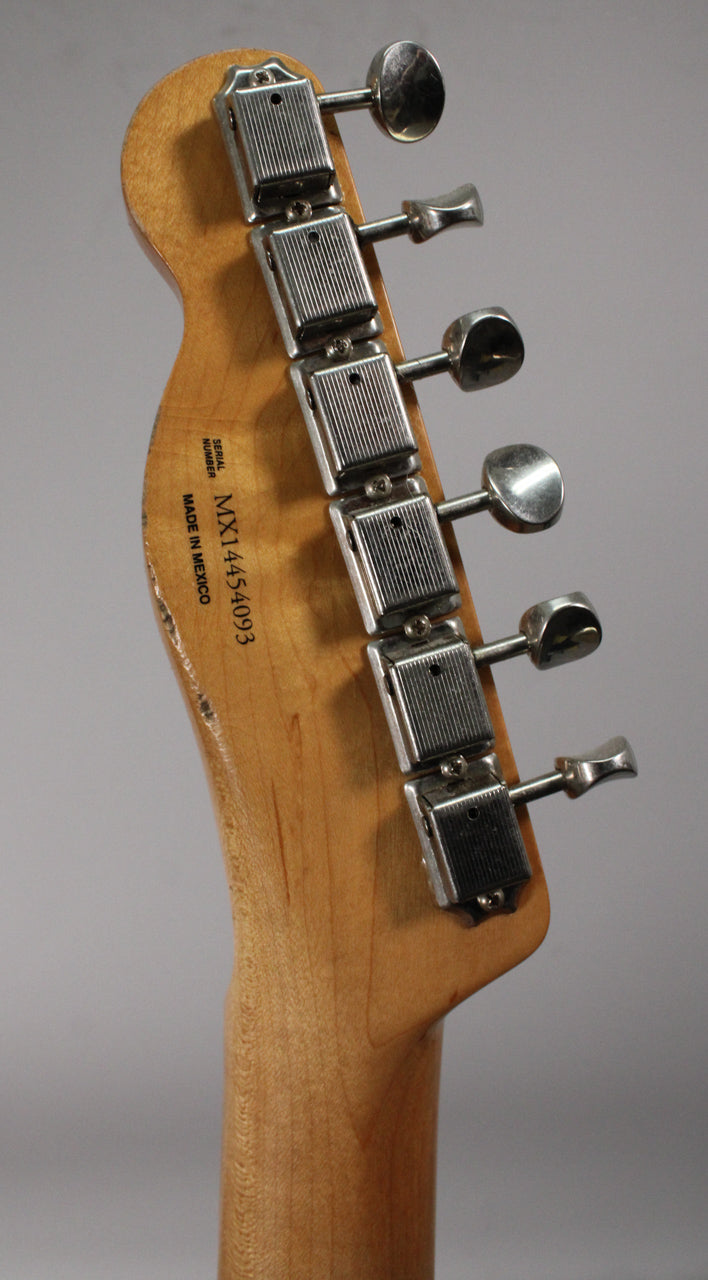 Rear view of the guitar's headstock and neck, showing six vintage-style tuners with rectangular housings and a worn, light wood finish.