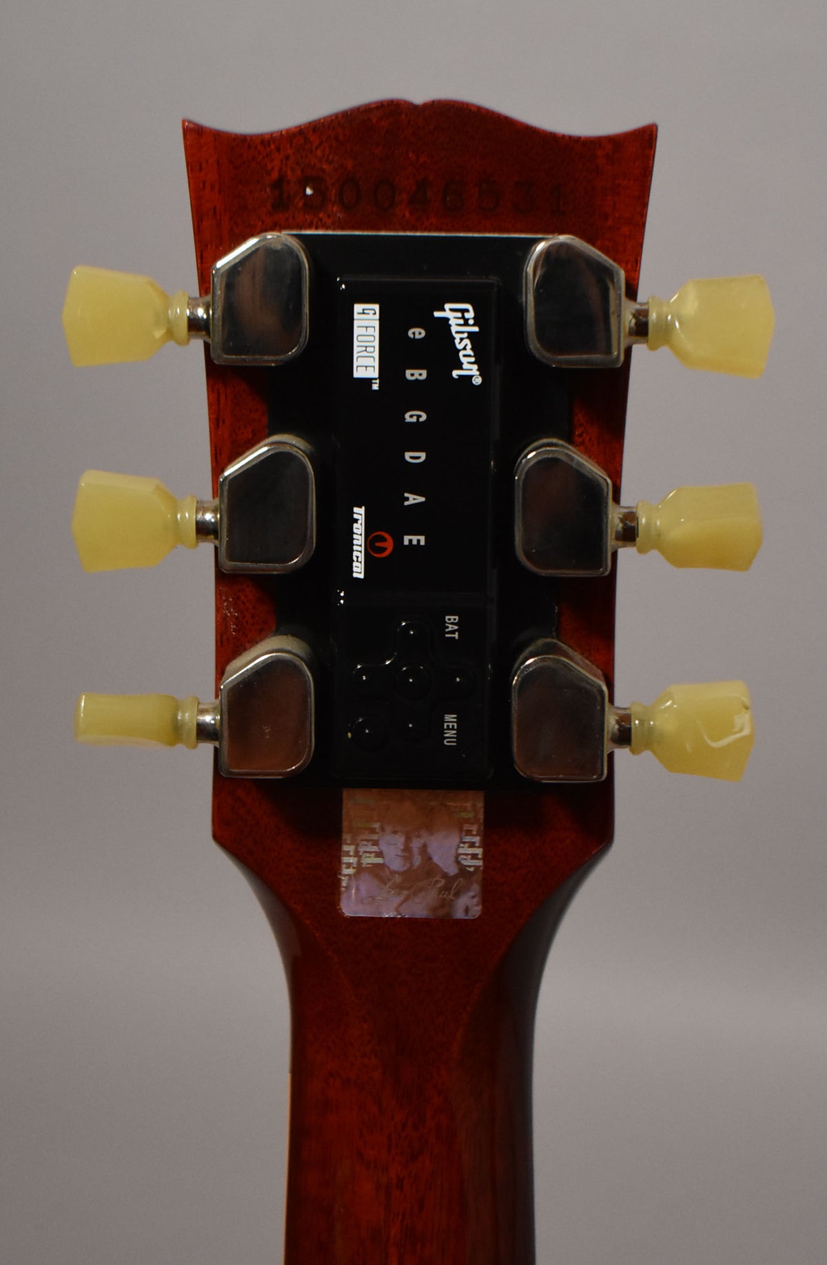 Rear view of the cherry red headstock and neck, showing six cream-colored tuners and a black G-Force automatic tuning system.