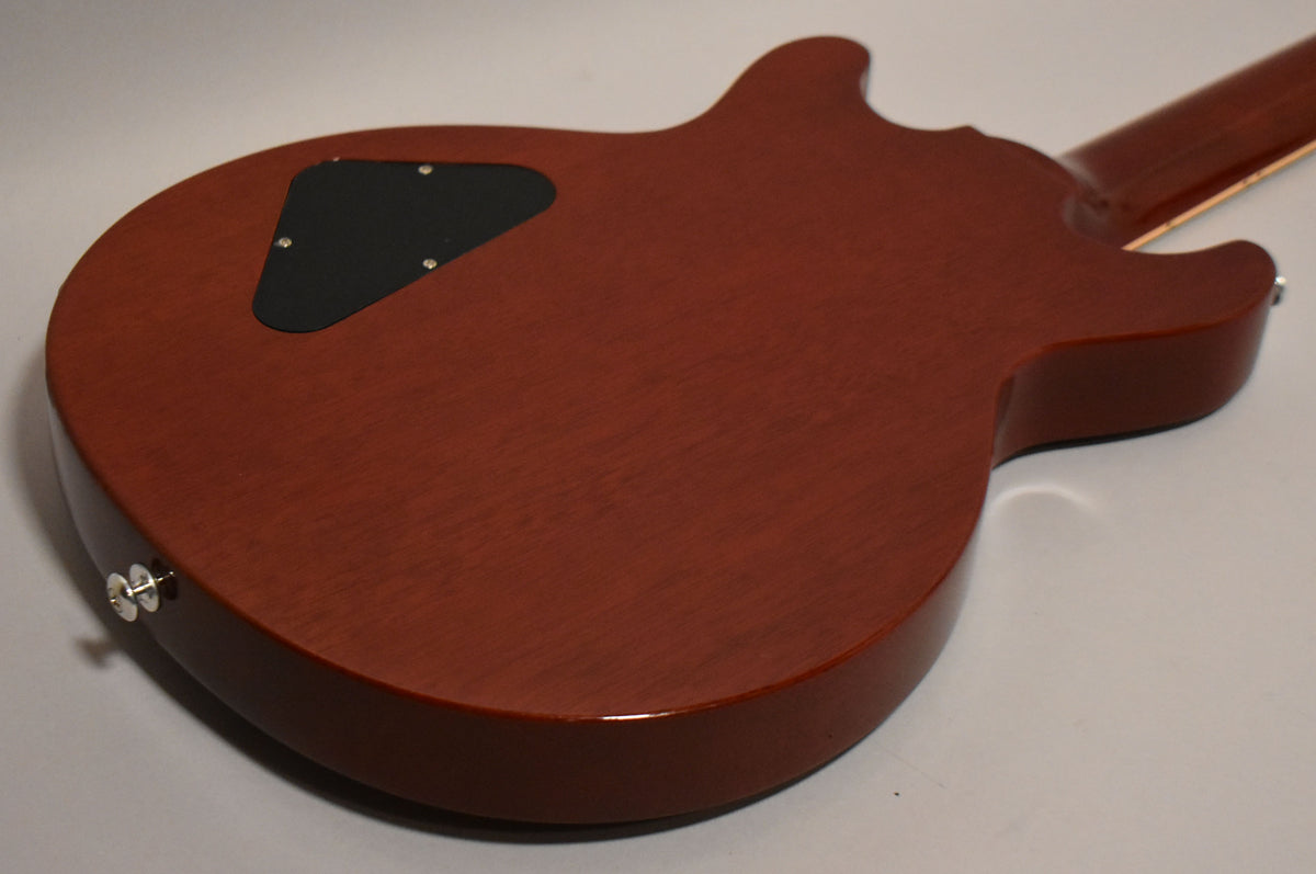 The back of the cherry red guitar shows a matte finish, a black control cavity cover, and a chrome strap button on the lower bout.