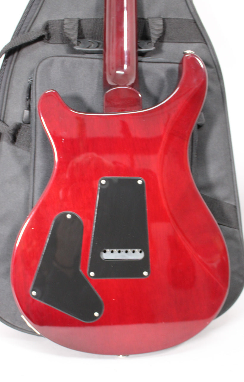 The guitar's translucent red back, with a visible wood grain, features two black control cavity covers and a matching neck.