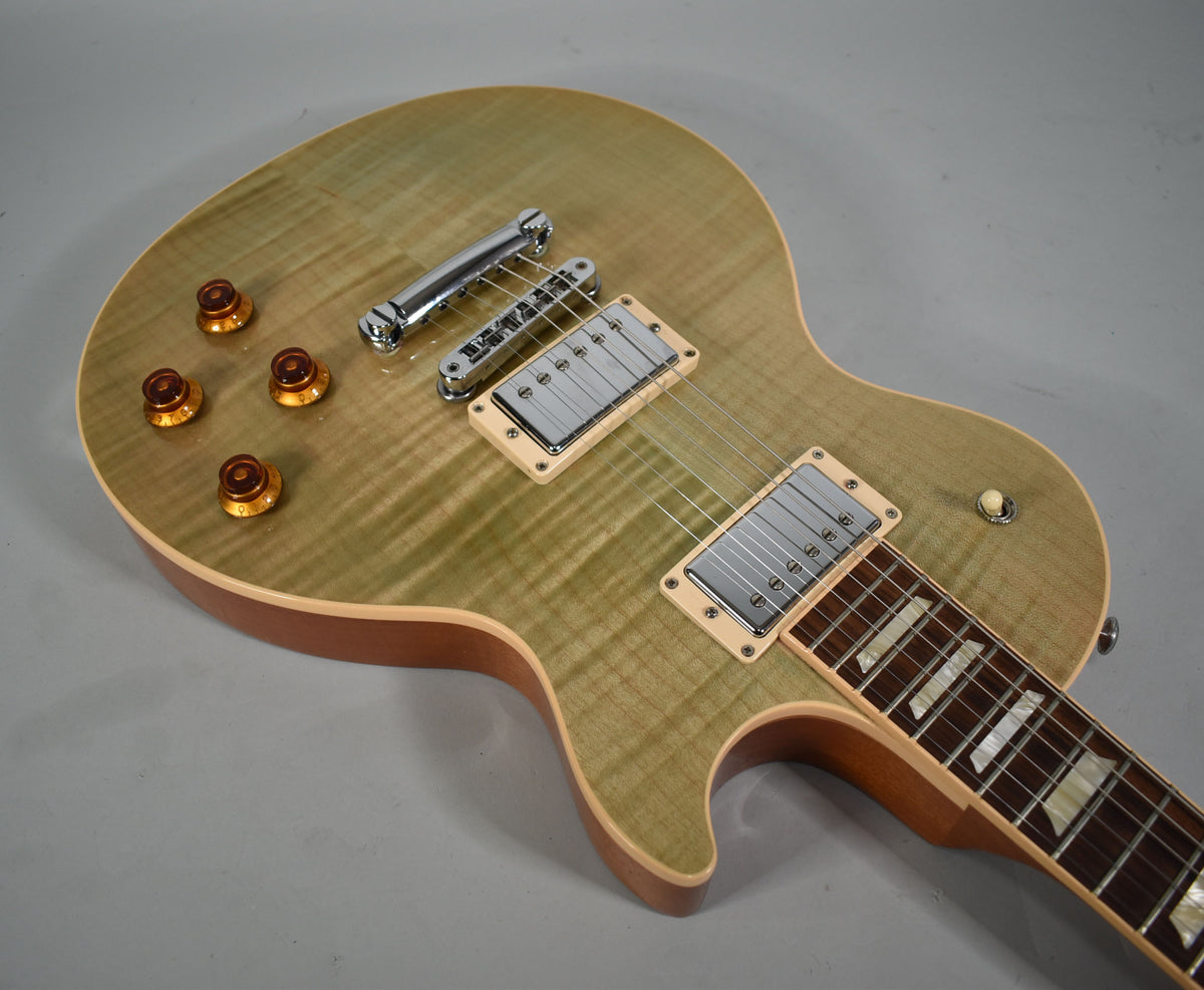Overhead view of a seafoam green Les Paul, showing its flamed maple top, chrome hardware, and amber top hat knobs.