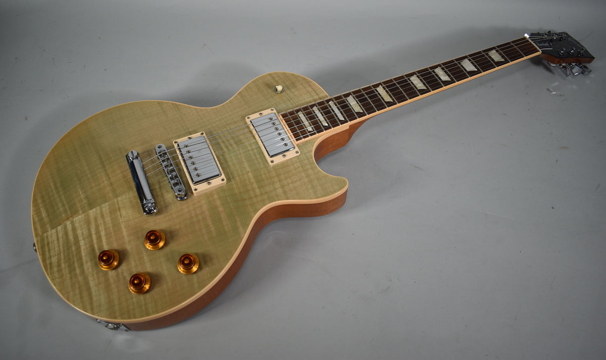 Full view of a seafoam green Les Paul with a flamed maple top, cream binding, chrome hardware, and amber top hat knobs.