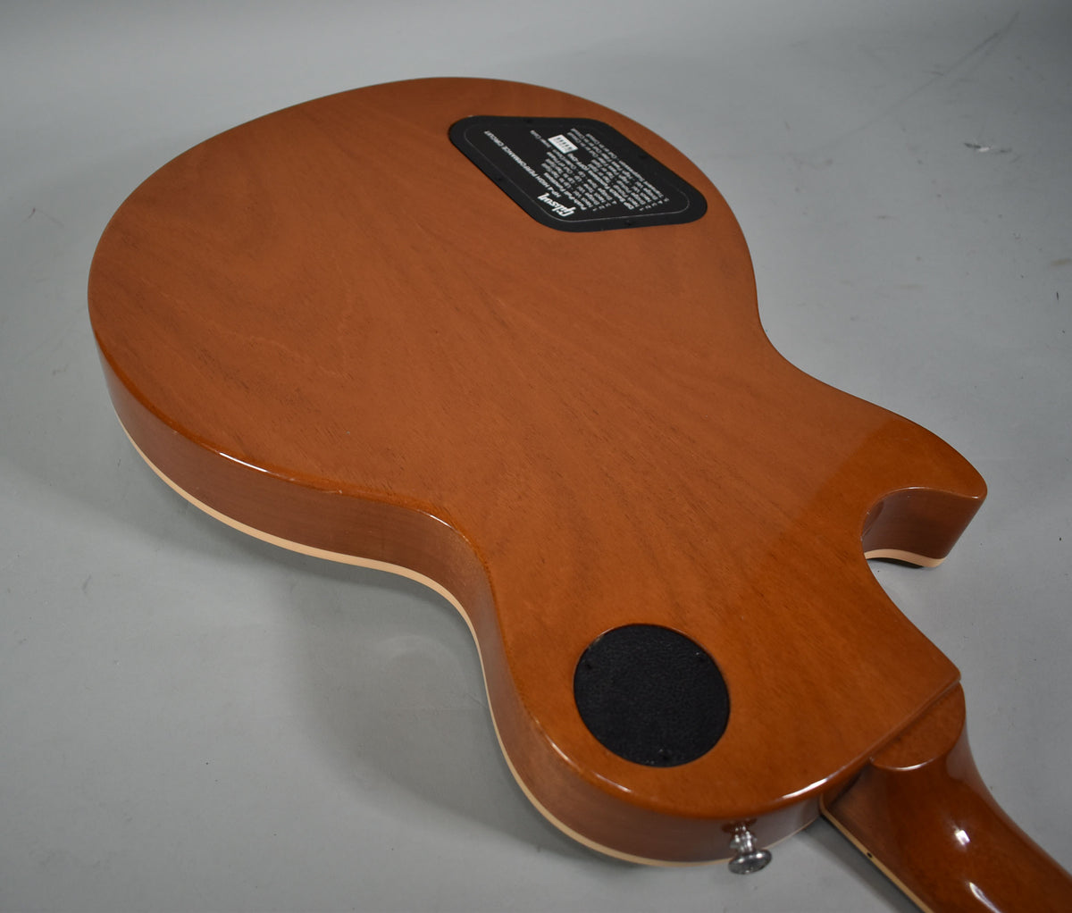 The back of a Les Paul Standard Plus, showing its glossy brown finish, cream binding, and black control cavity covers.